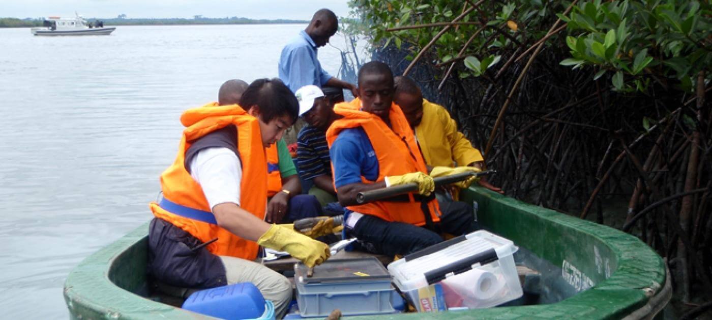 Researchers collecting and processing samples in a mangrove waterway