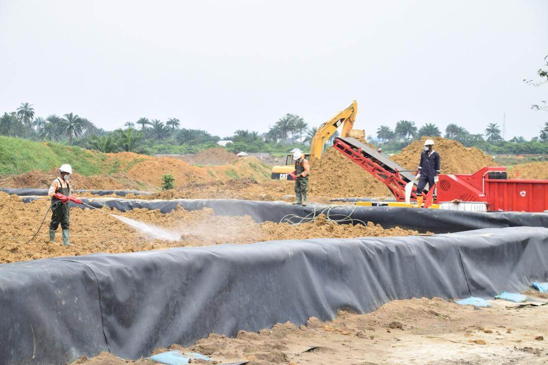 Worker at an engineered, lined treatment area at a remediation site
