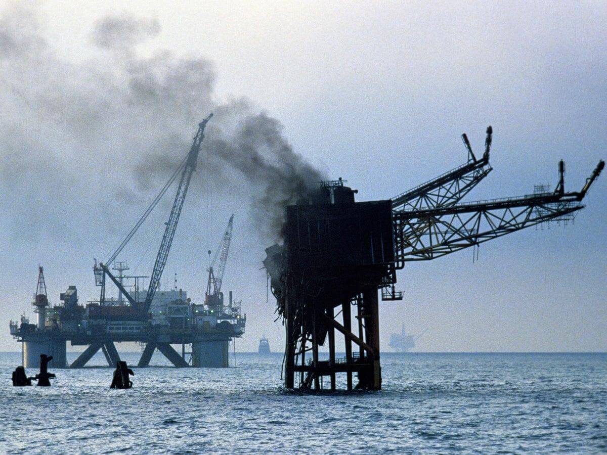 The remains of the Piper Alpha platform with smoke rising over the North Sea