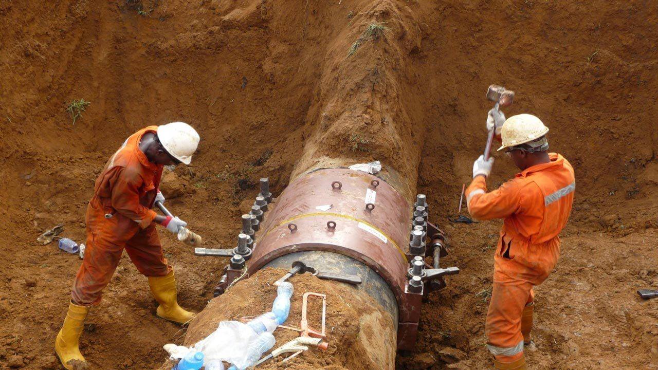 Technicians working on a pipeline repair clamp